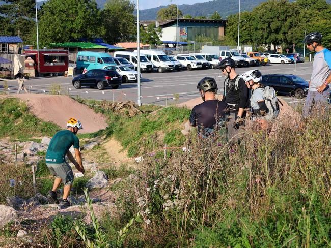 Guide erklärt Linienwahl im Trailcenter Aesch an Gruppe Biker